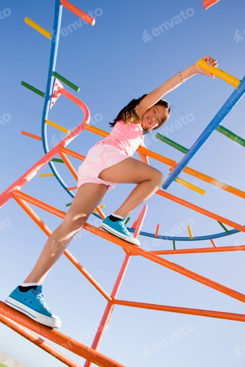 Preview: Vertical Shot Of A Girl Climbing On Monkey Bars At A Playground