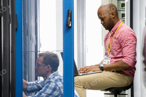 Preview: Wide Close Shot Of Two Technicians Sitting In The Data Center And Checking The Server