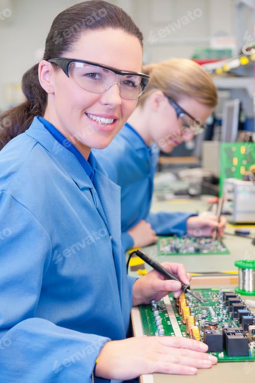 Preview: Portrait Shot Of A Technician Wearing Safety Glasses Smiling At The Camera While Soldering Circuit