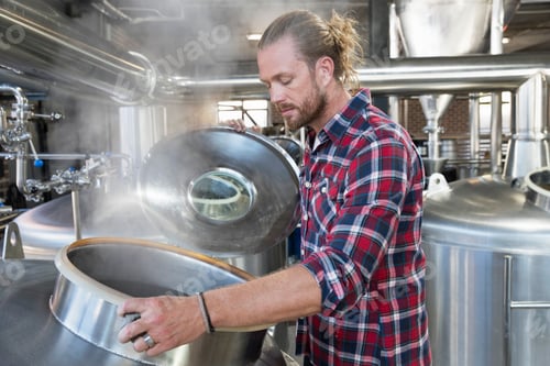 Preview: Brewery Worker Checking Fermentation Process In Steel Vat