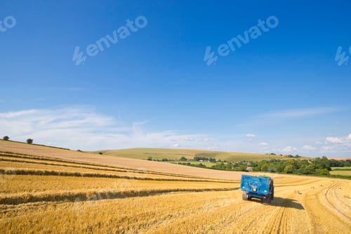 Preview: Tractor Pulling Trailer In Sunny Rural Field