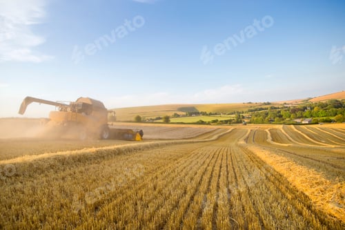 Preview: Combine Harvester Running Across A Dusty Field On A Sunny Day.