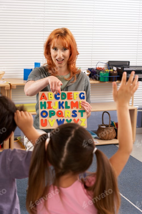 Preview: Children Learning Alphabets In Classroom With A Student Raising Hand.