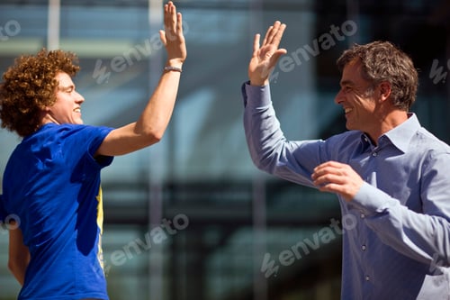 Preview: Happy Young Man And Mature Man Giving The 'High-Five' Gesture