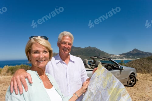 Preview: Couple With Car On Road Trip With Map On Coastal Highway At Camera