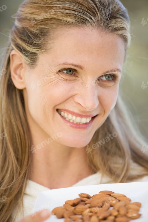 Preview: A Woman Holding A Dish Of Almonds