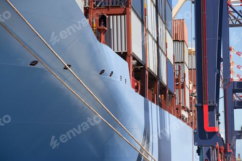 Preview: The Side Of A Container Ship With Cargo Containers Moored At A Commercial Dock.