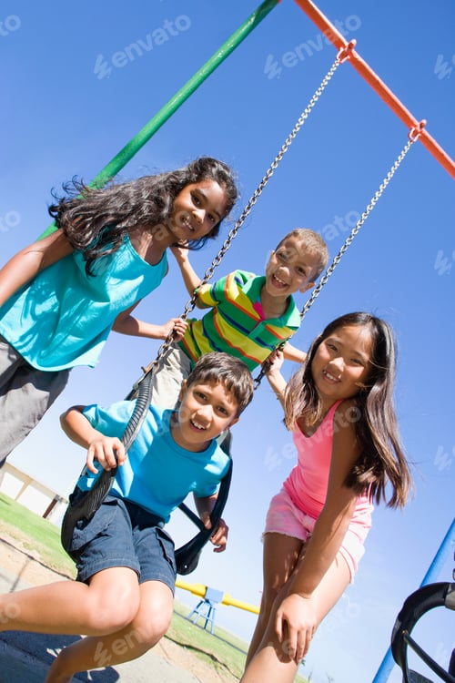 Preview: Children Smiling Together At A Swing Set On A Playground