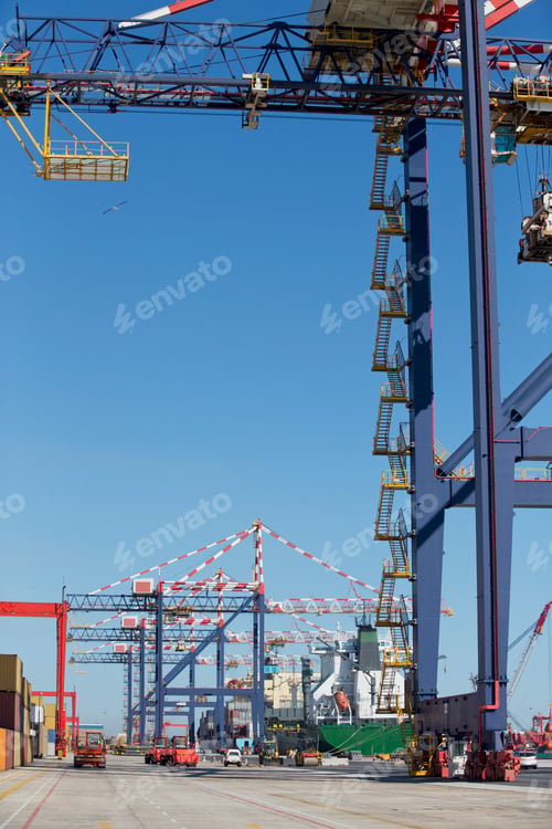 Vista previa: Vertical Shot Of A Row Of Gantry Cranes At A Dockyard