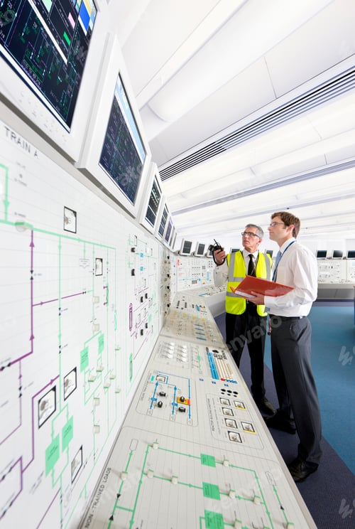 Preview: Vertical Shot Of A Senior Engineer In A Reflector Vest Speaking To A Young Engineer Looking At