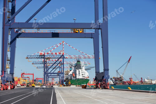 Preview: Wide Shot Of A Dockyard With A Row Of Gantry Cranes And A Ship