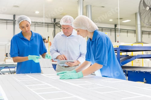Preview: Businessman And Technicians Arranging Solar Cells To Form A Solar Panel On Production Floor