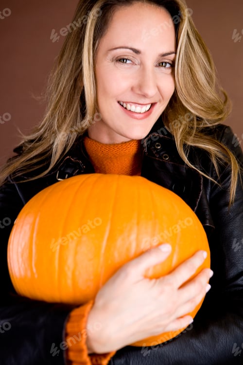 Preview: Studio Shot Of Woman Holding Pumpkin Smiling At Camera