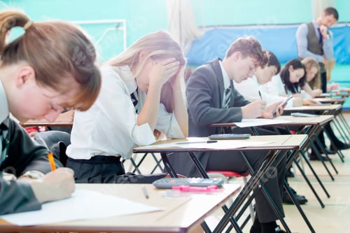Preview: Stressed Middle School Student Taking Examination At Desks In School Gymnastics Hall