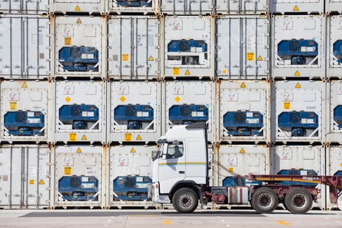 Preview: Container Truck Against Huge Stacks Of Cargo Containers At A Dockyard