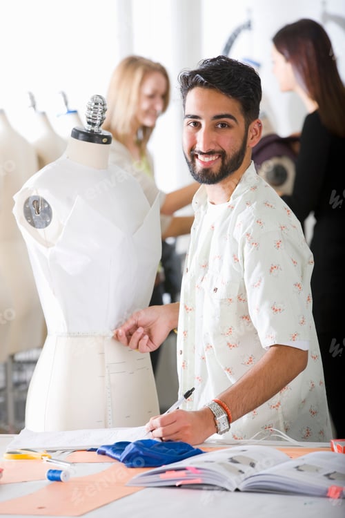 Preview: Vertical Shot Of A Young Fashion Design Student Smiling At The Camera While Measuring A Garment