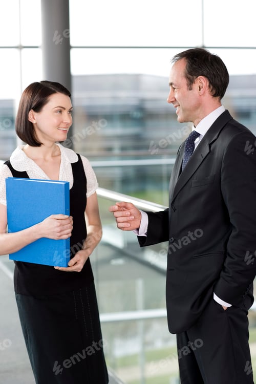 Preview: Male And Female Business Colleagues Chatting In Office Building