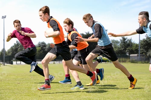 Preview: Middle Schoolboys And Teacher Running While Playing Rugby On The Field In Physical Education Class