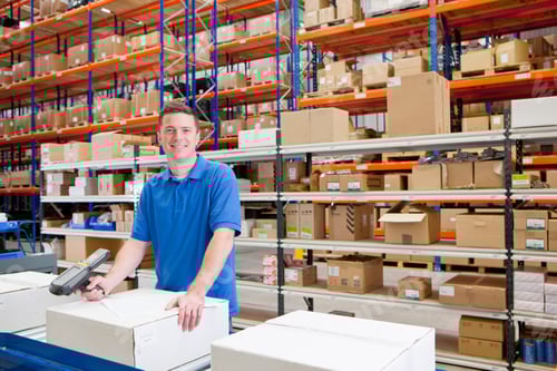 Preview: Medium Wide Shot Of A Worker Smiling At The Camera While Scanning A Box At The Production Line Of A