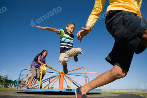 Preview: Wide Shot Of Children Jumping Off A Merry-Go-Round At A Playground