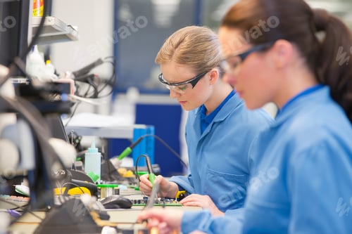 Preview: Medium Shot Of Female Technicians Soldering Circuit Boards On Production Line In A Manufacturing