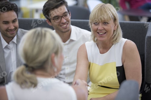 Preview: Businesspeople Meeting In Lobby Of Modern Office