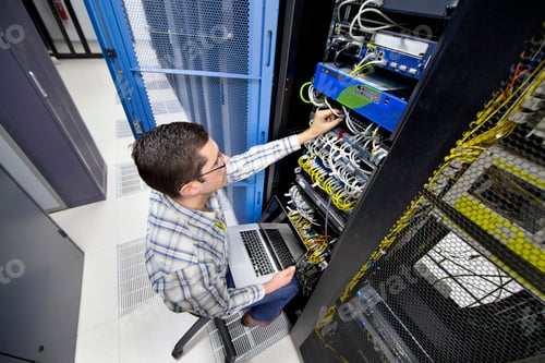 Preview: Close Up Of A Technician Checking The Wires Of A Server Using A Laptop In The Data Center