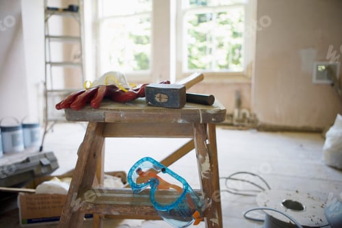 Preview: Close-Up Of Various Work Tools Lying On Top Of Step Ladder In An Undecorated Room In The House.