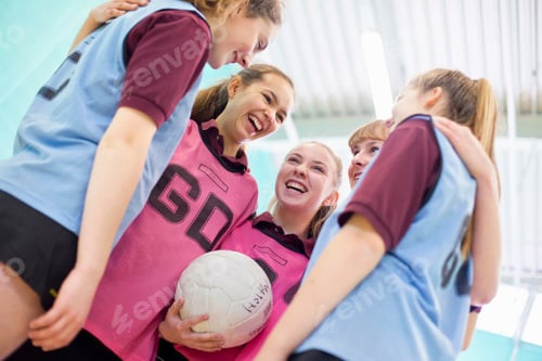 Preview: High School Volleyball Players Laughing While Hugging Each Other In A Huddle.