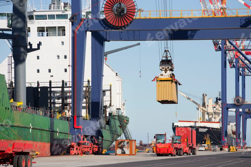 Preview: Wide Shot Of A Crane Lifting A Cargo Container From A Truck Next To Ship At A Commercial Dock.