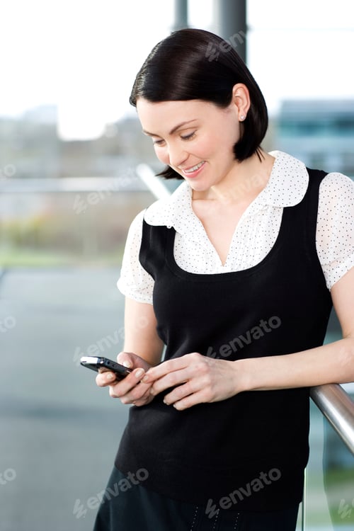 Preview: Young Businesswoman In An Office Using A Mobile Phone