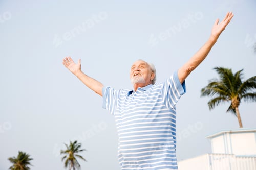Preview: Portrait Of A Senior Man Standing On A Beach With Arms Outstretched