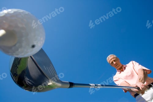 Preview: Mature Man Lining Up Tee Shot On Golf Course Holding Driver