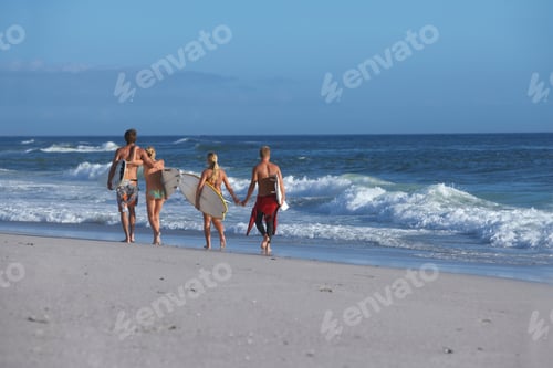 Preview: Wide Shot Of The Back Side Of A Group Of Friends In Swimwear Walking Along The Beach Holding