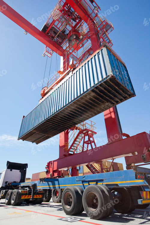 Vista previa: Low Angle Shot Of A Cargo Container Being Loaded On A Lorry At A Dockyard