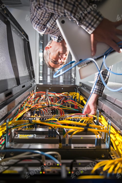 Preview: Technician Holding A Laptop And Checking The Wires In The Secured Data Center