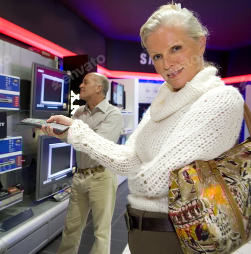 Preview: Mature Couple Shopping In Electrical Store For Television At Camera