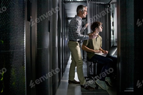 Preview: Wide Shot Of Two Technicians With A Laptop Working In The Secured Data Centre