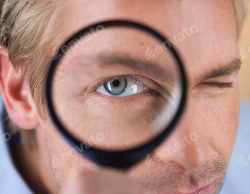 Preview: A Young Man Looking Through A Magnifying Glass