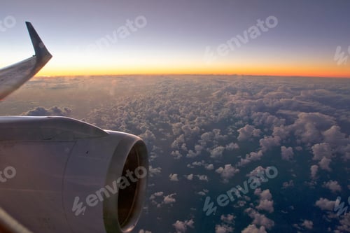 Preview: Sunset And Clouds View Through Window Over The Wing And Jet Engine Of A Passenger Plane