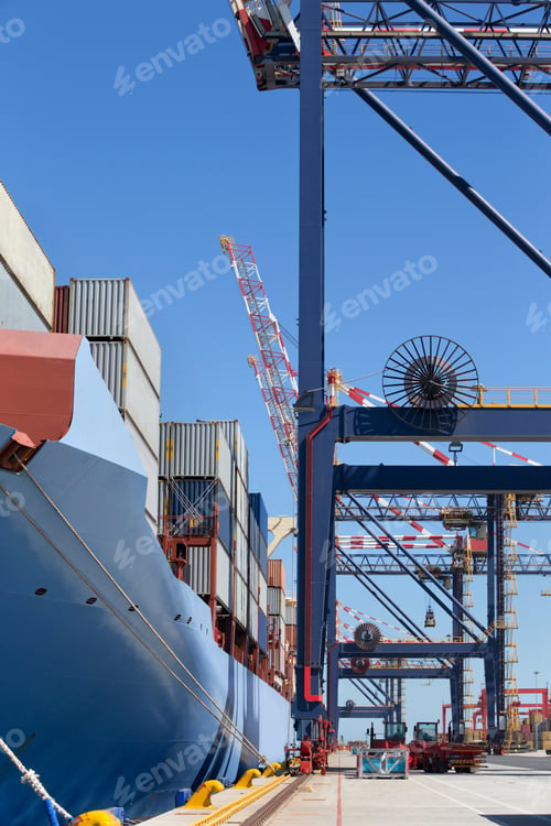 Preview: Vertical Wide Shot Of A Container Ship Loaded With Cargo Containers Moored At A Commercial Dock