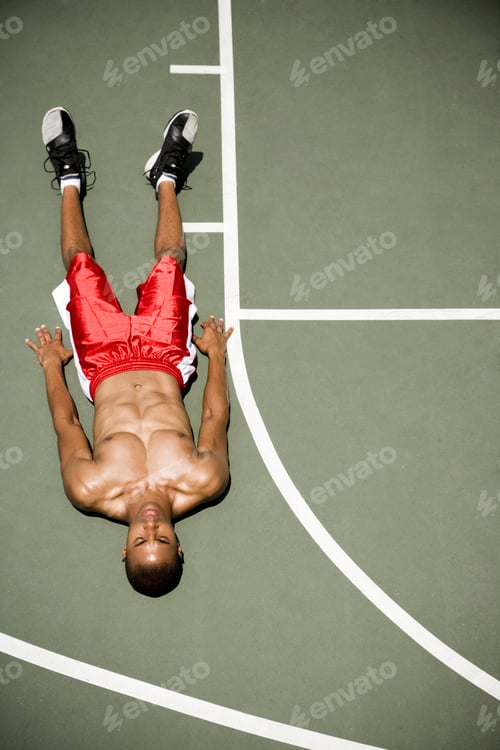 Preview: Man Laying Down On An Outdoor Basketball Court