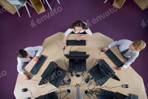 Preview: Overhead View Of Schoolboys And Schoolgirl In Private School Uniform Using Computers At The Table