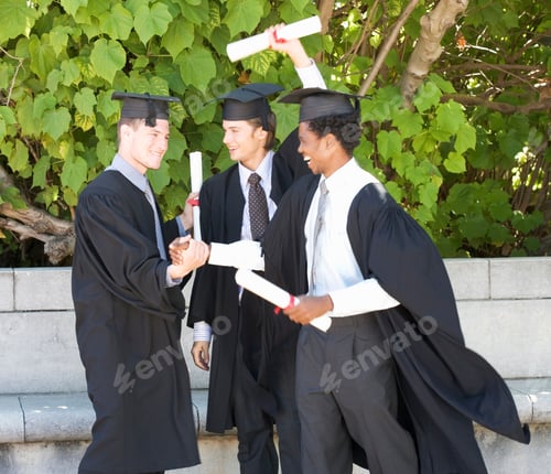 Preview: Male Graduates Celebrating Holding Awards Outdoors On Graduation Day