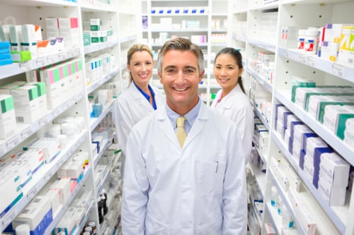 Preview: Portrait Shot Of A Team Of Pharmacists Standing Next To The Shelves At A Pharmacy And Smiling At