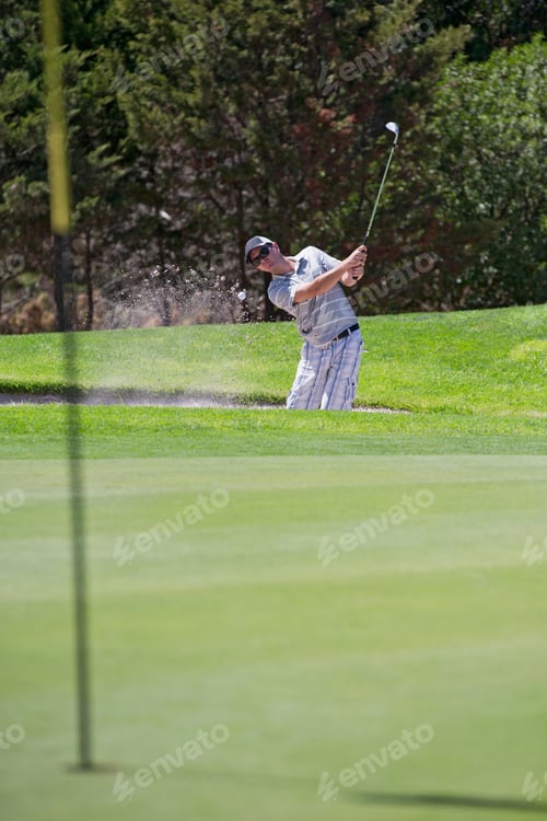 Aperçu: Male Golfer Hitting Ball Out Of Bunker Onto Green