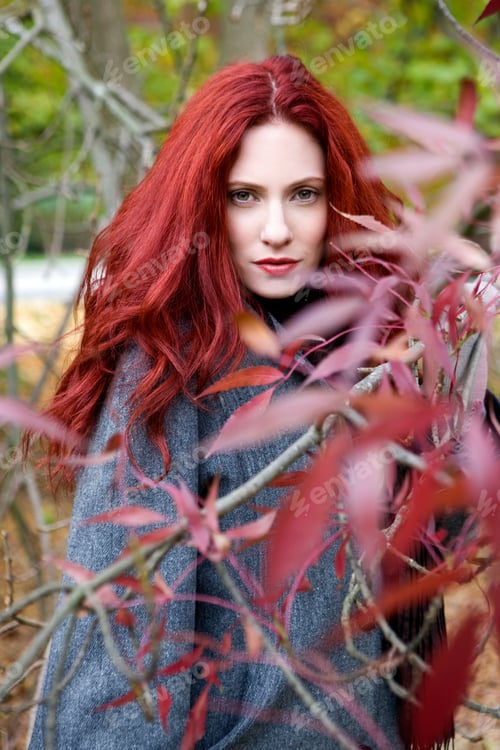 Preview: A Young Woman Standing Behind A Tree In Autumn Time