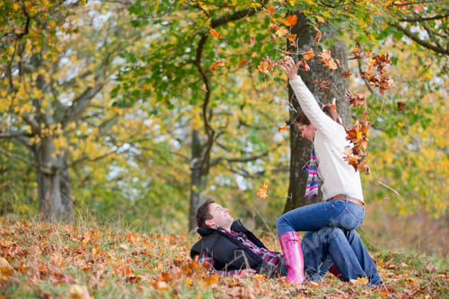Preview: Wide Shot Of A Couple Playfully Throwing Leaves In An Autumnal Park.