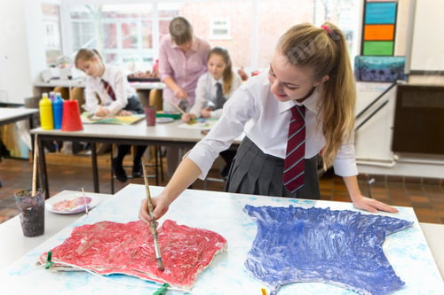 Preview: Medium Shot Of A Middle School Student Painting A Cloth Over A Canvas During An Art Class.