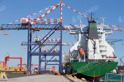 Preview: Close Up Of A Huge Ship Anchored At A Dockyard Beside A Row Of Gantry Cranes